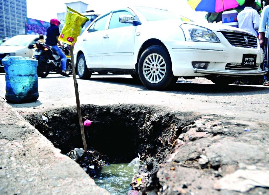 A big pot-hole filled with garbage on the busy road in city causing immense sufferings to commuters. This photo was taken from Purana Paltan area on Monday.