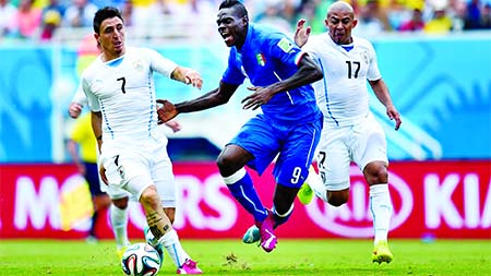 Mario Balotelli (C) of Italy competes for the ball against Cristian Rodriguez (L) and Egidio Arevalo Rios (R) of Uruguay during the 2014 FIFA World Cup Brazil Group D match between Italy and Uruguay at Estadio das Dunas in Natal, Brazil on Tuesday.