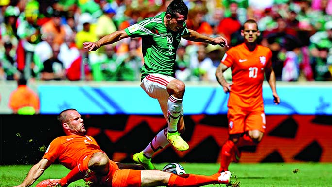 Ron Vlaar of the Netherlands tackles Hector Herrera of Mexico during the 2014 FIFA World Cup Brazil Round of 16 match between Netherlands and Mexico at Castelao in Fortaleza, Brazil on Sunday.